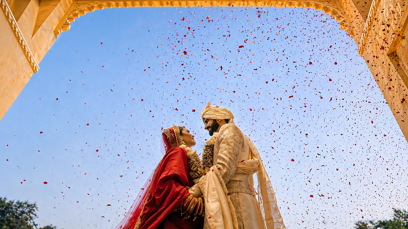 Indian wedding couple with rose petals falling around them